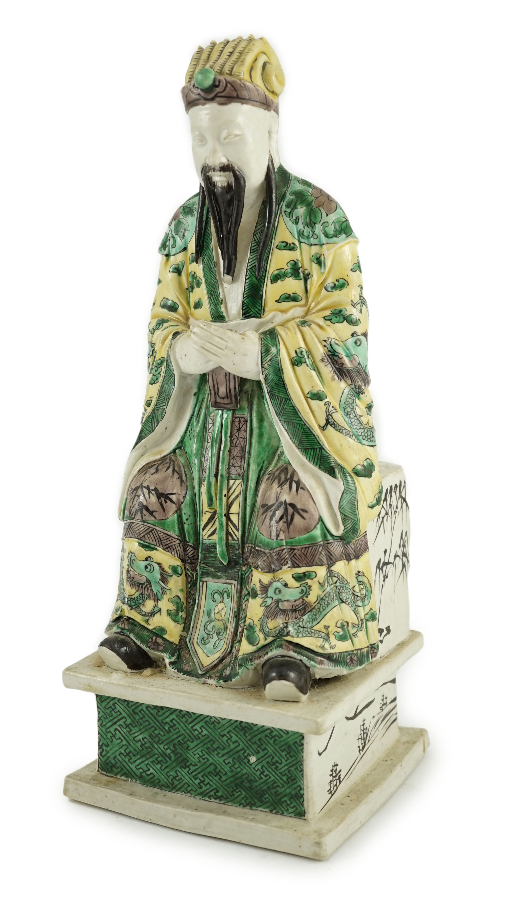 A Chinese enamelled biscuit figure of a seated court official, Kangxi period, 31.5cm high, small losses
